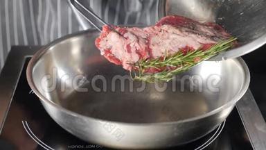 把一块肉放在煎锅上。 厨师在餐厅厨房做饭。 快关门。 双手合拢准备牛排
